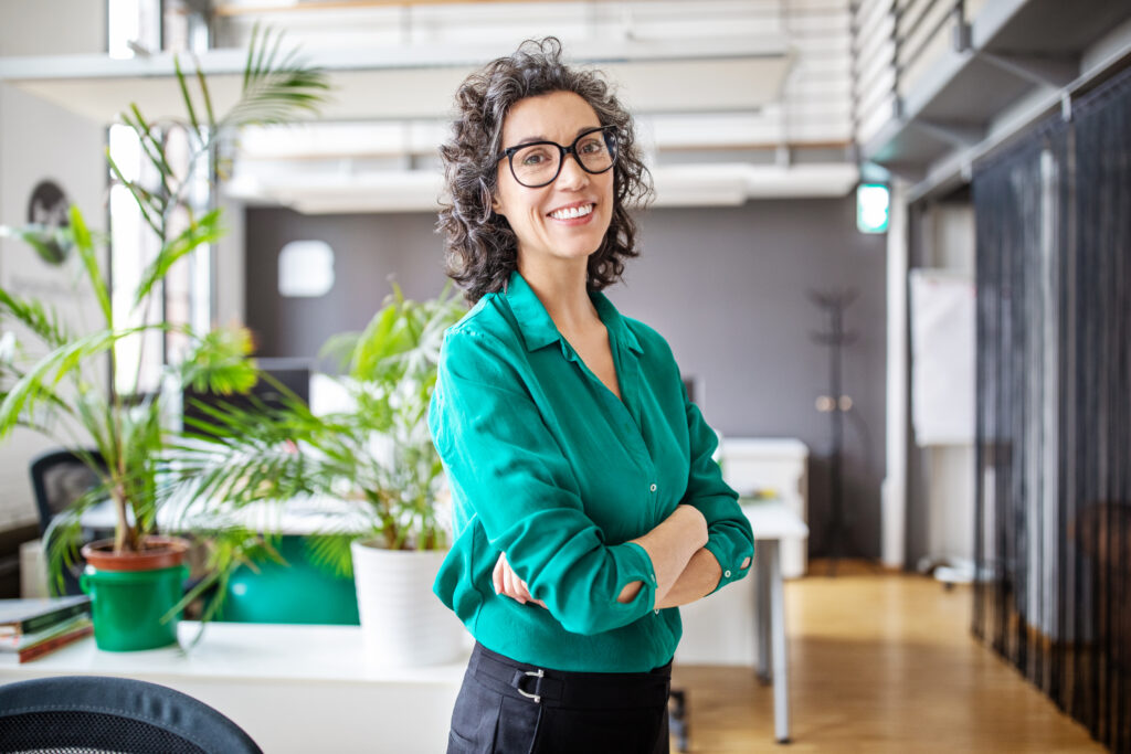 Portrait of a happy businesswoman standing with her arms crossed.