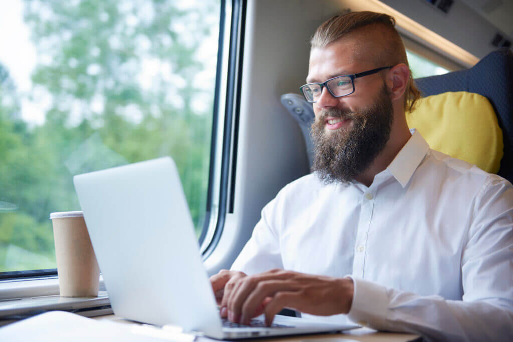 This is an image of a businessman with beard working during train journey